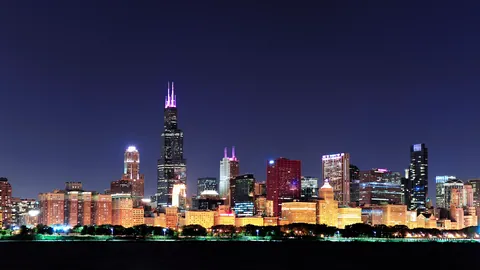The Chicago skyline sparkling across the dark lake at night.