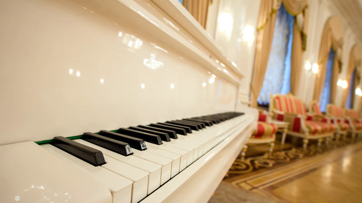 A grand piano in a hushed hall before the doors open.