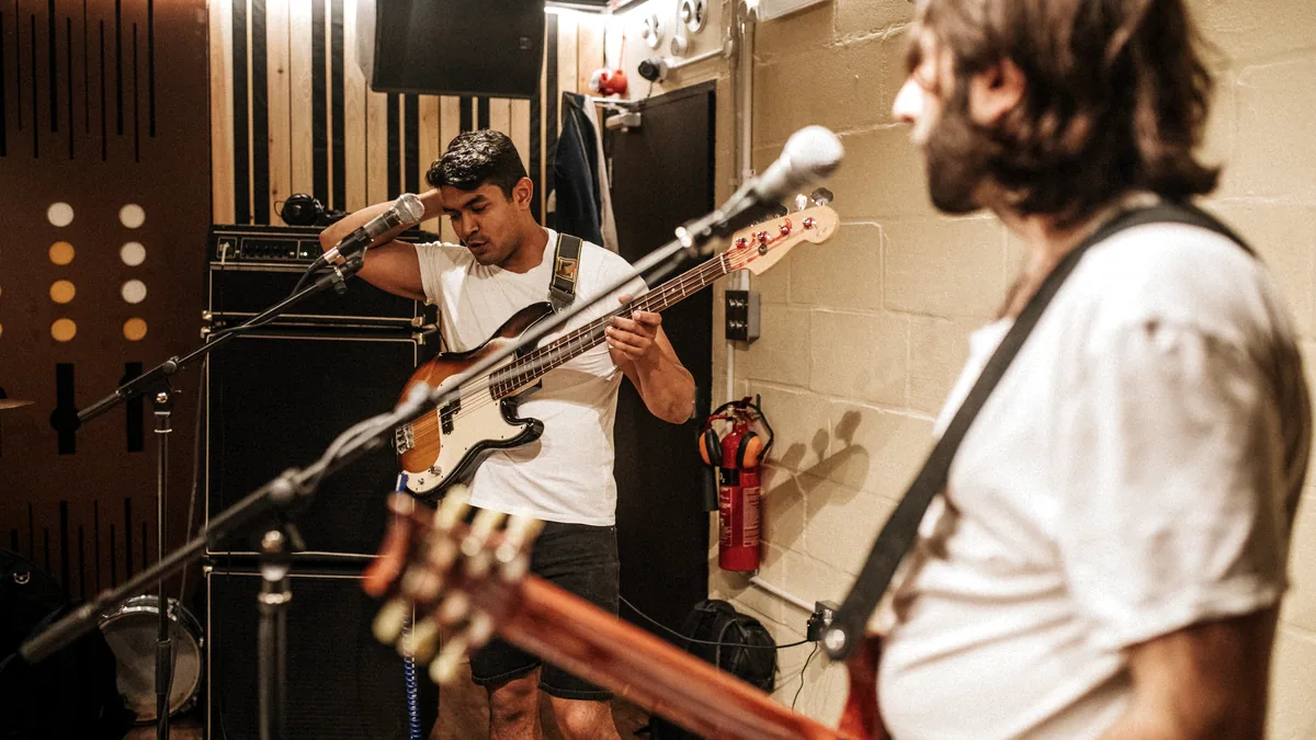 A small band tuning up in a cluttered rehearsal room.