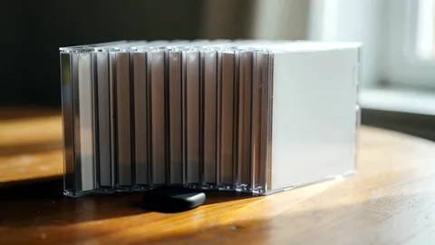 Illustration: New CD cases in their jewel boxes lined up on a wooden table.