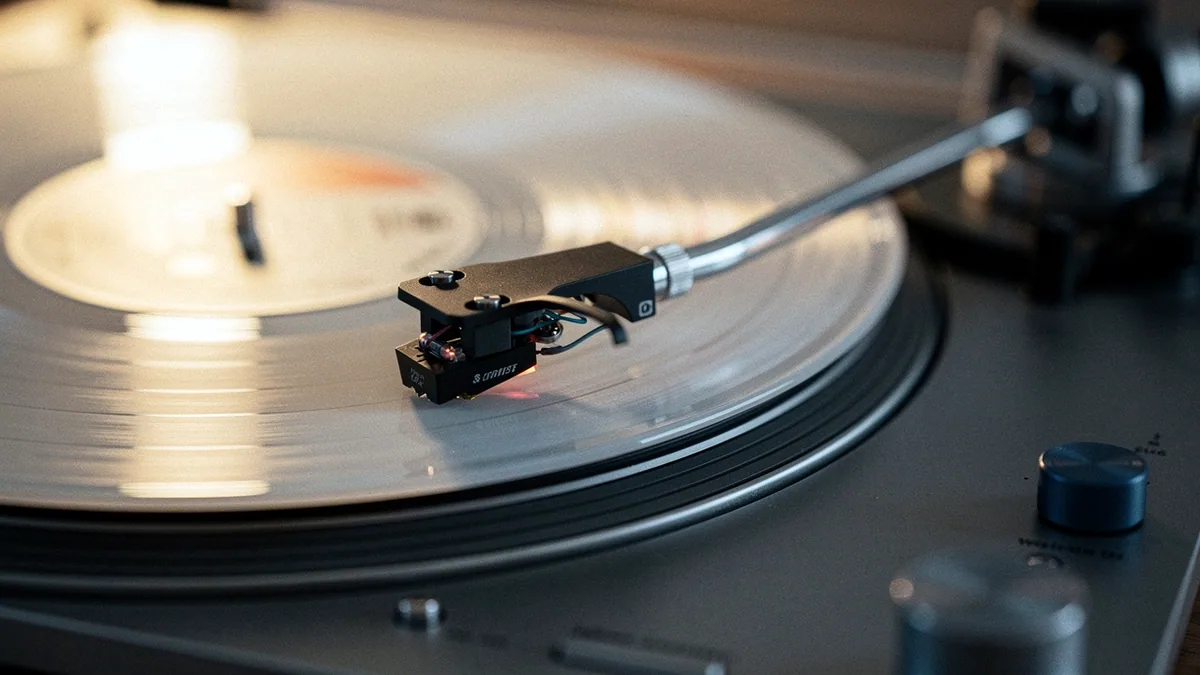 Illustration: A vinyl record on a spinning turntable with the tonearm lowered.