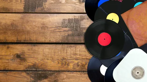 A stack of fresh vinyl records spread out on a table.